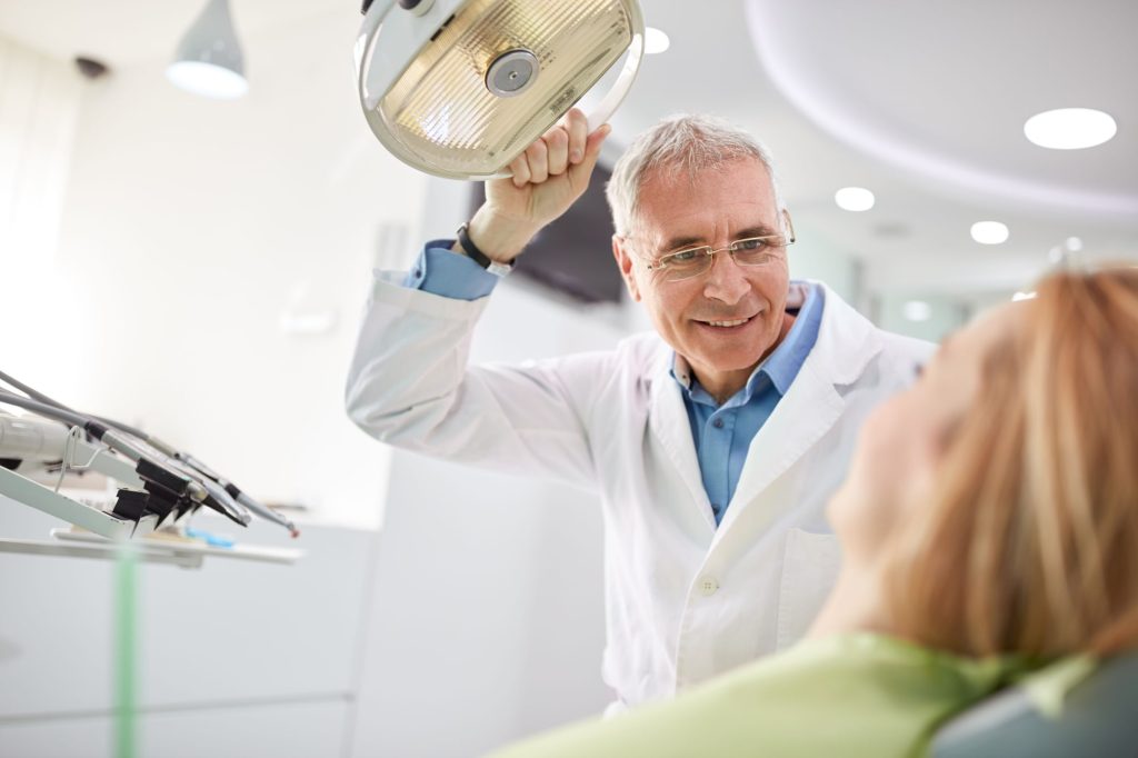 dentist holding light happy