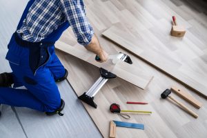 man kneeling over hardware supplies