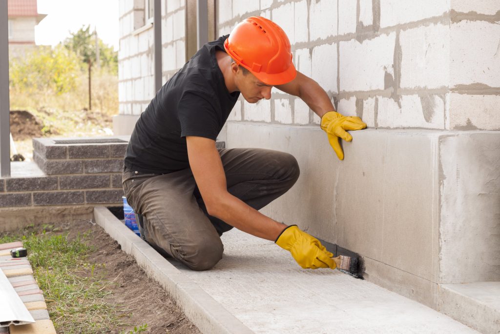 foundation repair worker sealing foundation