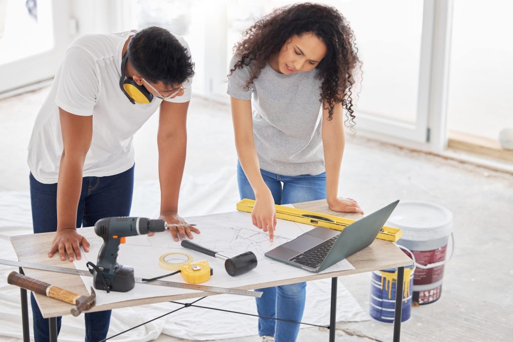 home remodel workers in demo looking at laptop