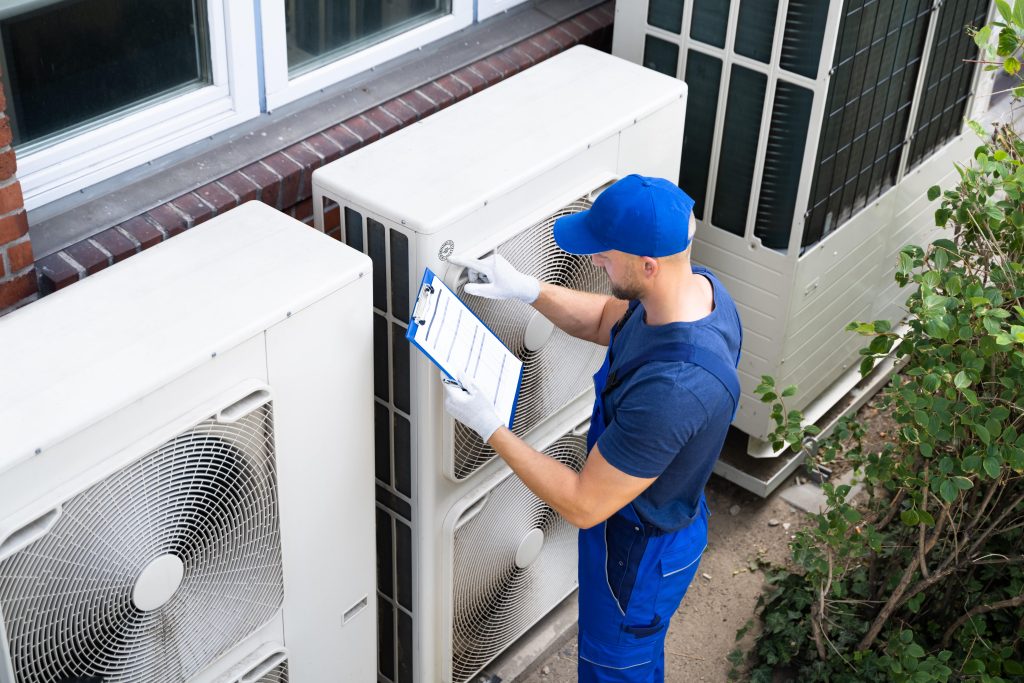 hvac repair man inspecting ac unit