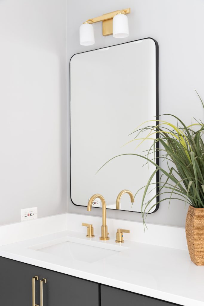 bathroom remodeled with white countertop and gold finishes