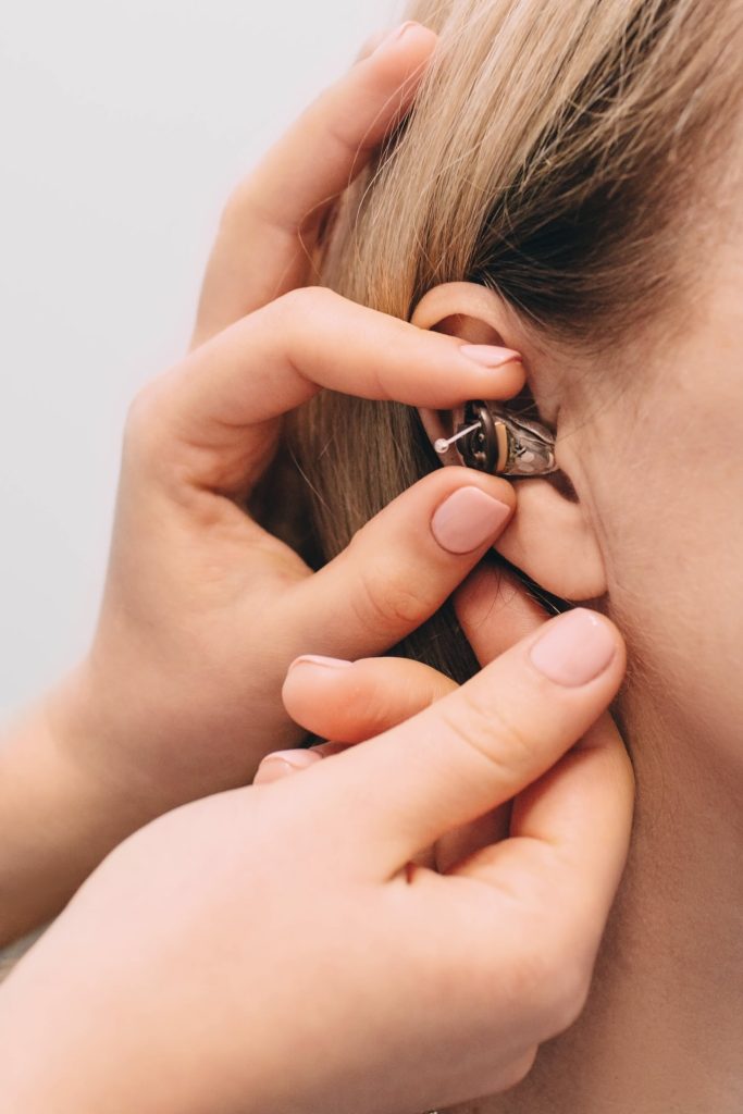 close up hearing aid being inserted into ear