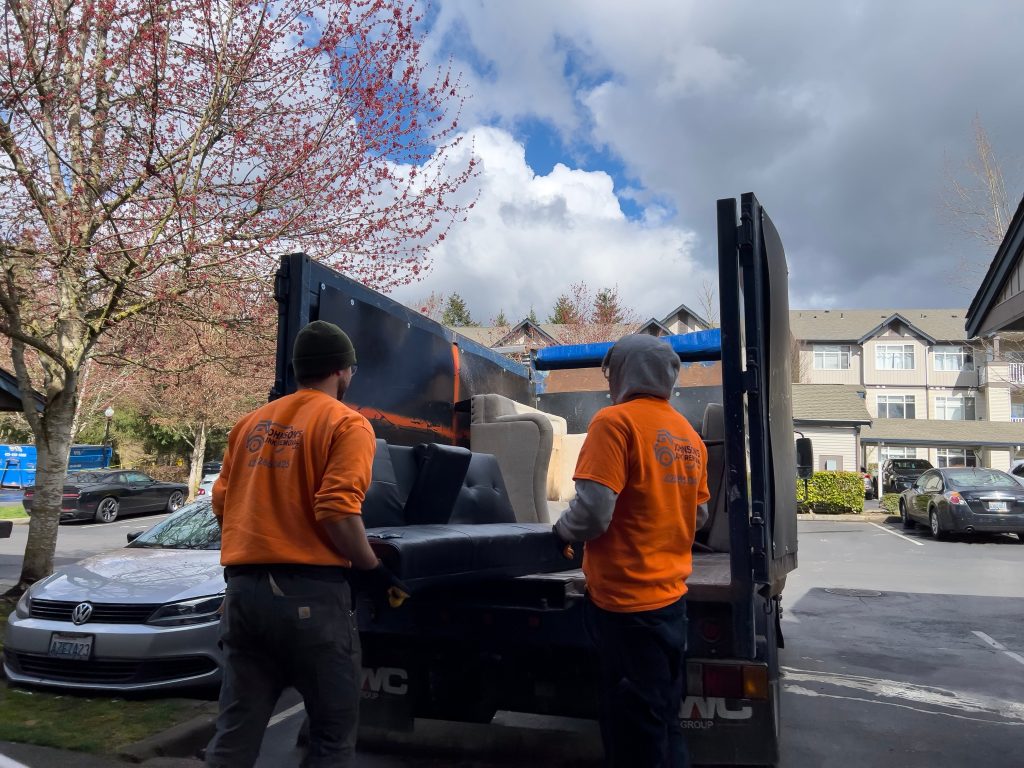 junk removal workers loading items into truck