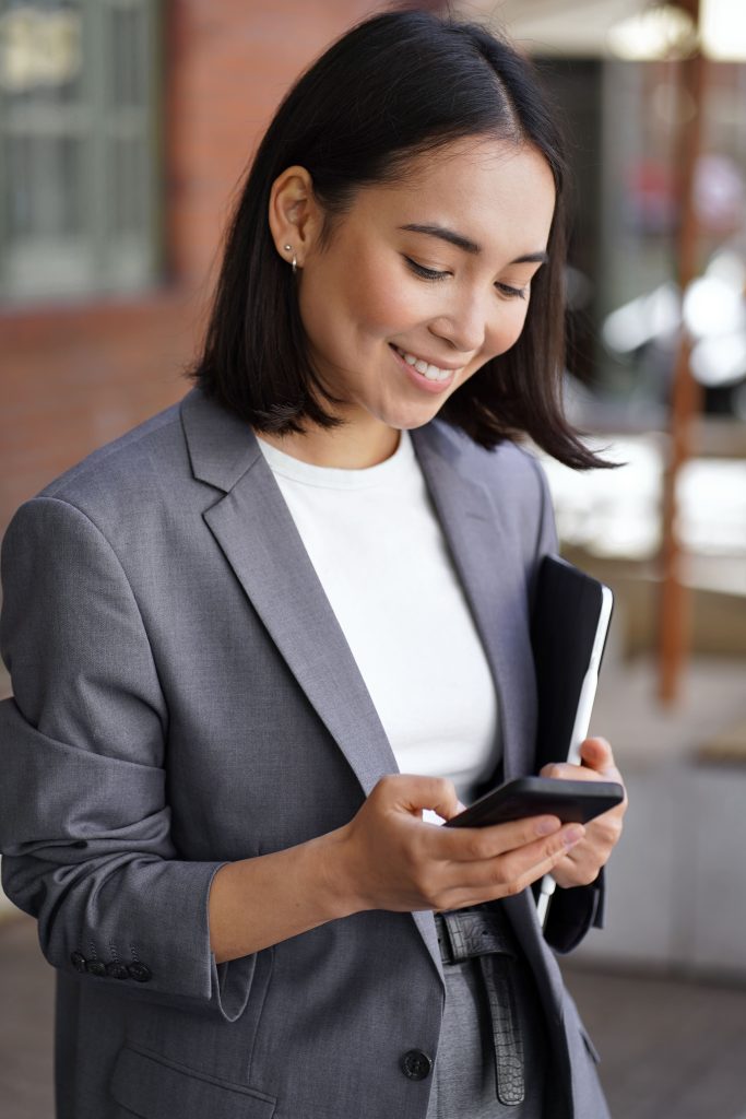 young woman smiling on phone with clipboard