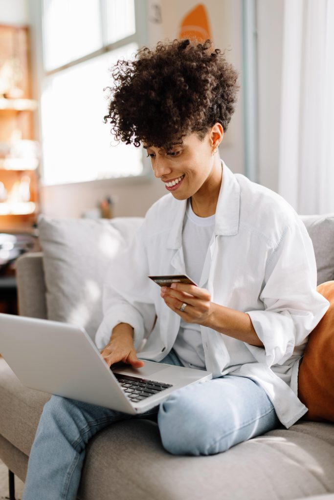 woman on couch with laptop and credit card