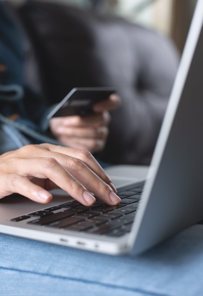 woman on laptop holding credit card