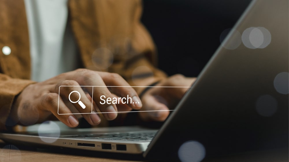 close up of women typing on computer. Search concept with search bar.