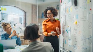 woman standing at whiteboard and leading presentation